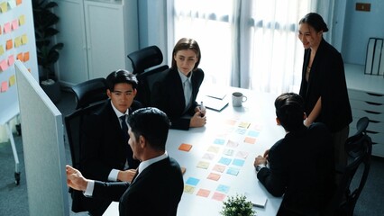Wall Mural - top view of smart businessman putting sticky note on whiteboard while marketing team brainstorm crea
