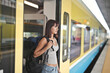© olly - young woman exits a train