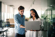 © NDABCREATIVITY - Two happy diverse multiethnic business team people working, talking in corporate office