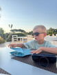 © Elena - Young Boy Relaxing Outdoors with Sunglasses