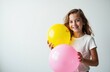 © starush - Woman holding colorful balloons smiling in front of a plain white background
