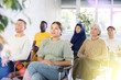 © JackF - Young woman in casual clothes listens to lecture while sitting on chair in office