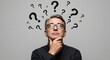 © Khasani - Middle-aged man contemplates with question marks surrounding his head, pondering.