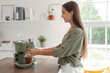 © Pixel-Shot - Beautiful young happy woman making coffee with machine at kitchen in office