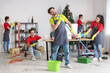 © Pixel-Shot - Team of janitors cleaning in office after New Year party