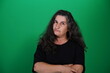 © Artframe  - Woman with a variety of emotions, wearing a black t-shirt ,standing against a green background. Studio shot with copy space. Not edited image