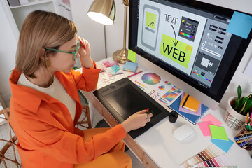 Female web designer working with graphic tablet at table in office