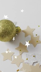 Wall Mural - golden bauble with christmas decorations over star confetti animation