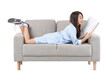 © Pixel-Shot - Young Asian woman reading magazine on grey sofa against white background