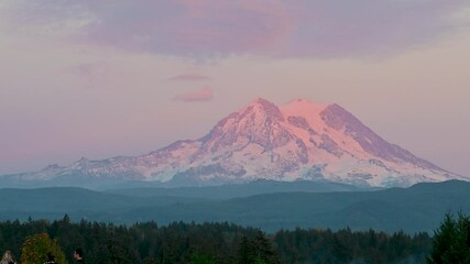Sticker - Pink and purple skies bathe Mount Rainier in soft light during a peaceful aerial view over forested foothills at sunset