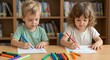 © Helen - Young boy and girl drawing with colorful markers at a wooden table in a classroom or library. Early childhood education and creative development concept.