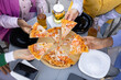 © sofiko14 - A group of friends enjoying pizza and drinks outdoors, capturing a moment of leisure and shared mealtime.