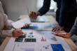© Wasana - A group of people are looking at a table with graphs and charts