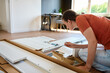 © Lazy_Bear - Woman assembling new bed at home, sitting on floor and reading instruction manual. Concept of DIY home furniture assembly, home improvement and self installation process in modern interior