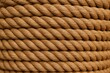 © AkuAku - Brown rope texture in a coiled bundle with an abstract backdrop