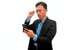 © Isman - An Asian man wearing a suit holding a cell phone with a thinking expression