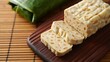 © Gumbz - Sliced tempeh on wooden board with bamboo background healthy vegetarian food