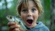© laperuz - Excited young boy holding caught fish while smiling outdoors in nature