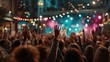 © Inkwell Imagery - Energetic crowd raising hands at vibrant outdoor concert with colorful stage lights for event marketing.