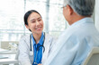 © whyframeshot - Asian healthcare professionals conduct medical consultations with senior patients using digital technology. Doctor examines elderly woman with stethoscope during comprehensive checkup