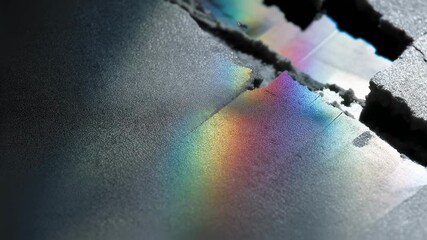 Wall Mural - rainbow colors shining through cracked pieces of material creating an abstract and innovative compos
