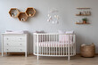 © Rashed - Minimalist Baby Nursery Featuring White Crib Pink Bedding Wooden Shelves and Mobile Pastel Colors Light Grey Walls