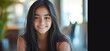 © Vergiliy - Smiling teenage girl with long dark hair in cozy indoor setting.
