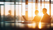 © RachelKolokoffHopper - Colleagues engaged in discussion during a bright sunset in a modern office environment