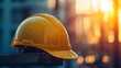 © Your Hand Please - Construction worker’s yellow hard hat helmet with blurred American flag in the background. Symbolizing Labor Day, workers’ pride, and American workforce. Space for caption on the side.