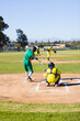 © Wavebreak Media - Diverse male athletes swinging metal bat, catching baseball near chalk baselines on community field