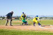© Wavebreak Media - Man sliding into home plate wearing helmet on baseball field with baseball glove and dust rising