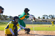© Wavebreak Media - African American batter swinging bat at home plate with catcher crouching nearby holding mitt