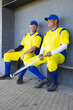 © Wavebreak Media - Two male baseball teammates sitting on bench in dugout leaning against wall holding glove and bat