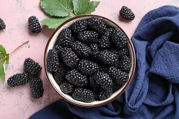 Wall Mural - Composition with bowl of ripe blackberry on pink grunge background, closeup