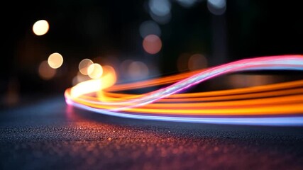 Wall Mural - abstract video of glowing light trails in orange, blue, and pink hues on a dark background. the ligh
