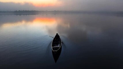 Wall Mural - silhouetted boat on calm water at sunrise, misty atmosphere, soft orange and gray tones, tranquil sc