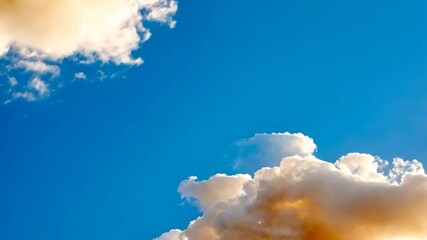 Wall Mural - low angle view of a vibrant blue sky adorned with fluffy white and warm orange-hued clouds. the sun'
