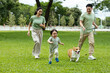 © saltdium - An Energetic young boy and Corgi enjoying active moments with family at the park