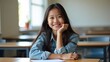 © Khatthaphone - Confident Teenage Girl Smiling in Classroom with School Supplies and Learning Environment