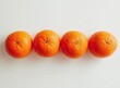 © Critink - Four bright orange mandarins arranged in a straight line against a plain white background, viewed from directly above