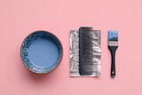 Flatlay of hair dye bowl, comb, foil, and brush on pink background. Lavender dye is visible in the bowl. Tools are neatly arranged for at-home hair coloring