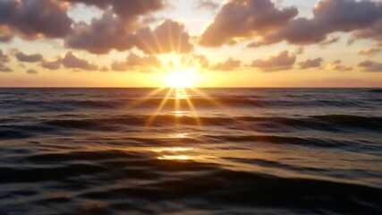 Wall Mural - close-up view of a sunlit ocean surface at sunrise or sunset. the golden light reflects on the dark 