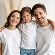 © Alena - Family of three standing together. Mother, father and daughter in blank white tshirts mockup. Young woman, man and 4 years old girl. Mom, dad with one baby matching design short sleeve t-shirts