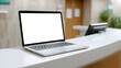 © Oksana_Latysheva - Modern laptop with blank white screen placed on hospital reception counter. Ideal for medical app mockups, healthcare UI, or telemedicine visuals. Clean and professional setting.