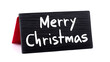 © Oksana_Latysheva - Wooden-framed mini chalkboard with Merry Christmas written in white chalk. Neutral and versatile, this decor piece suits greeting card layouts, product mockups, or seasonal ads.