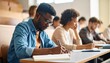 © NafiliaEmil - A young black student is taking notes on a notebook during a lesson.