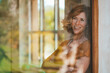 © Westend61 - Happy mature woman seen through glass window