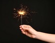 © Darni - Hand holding sparkler against black background (1)