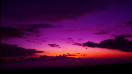 Wall Mural - Warm sunlight sinking below distant horizon, painting expansive cloudscape with vibrant orange, pink, purple hues during twilight transition