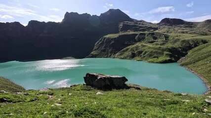Wall Mural - turquoise waters of lago vannino reflecting sunlight beneath steep mountain shadows in the lepontine